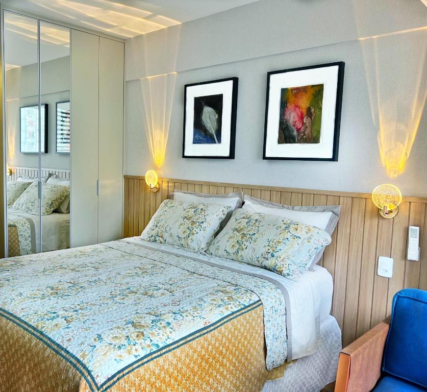 a bedroom with a bed and two pictures on the wall at Carnaval com conforto e vista incrível - Studio com rooftop, piscina vista mar e academia in Salvador