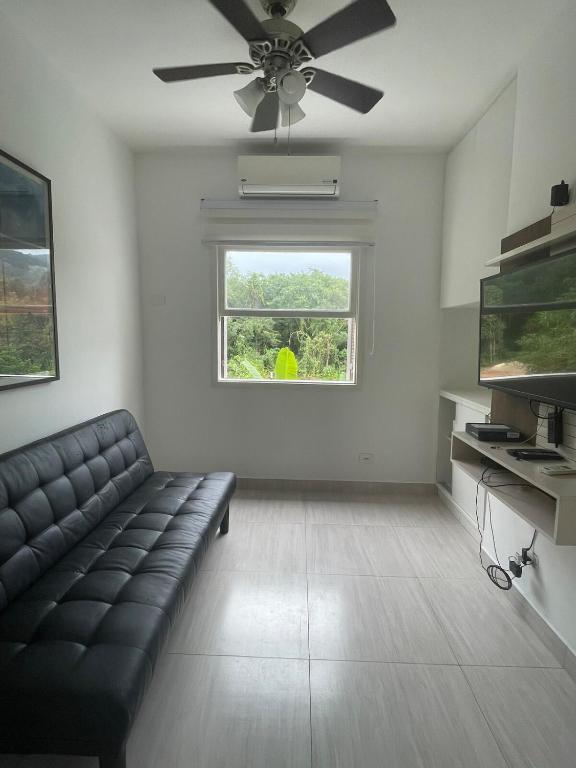 a living room with a couch and a window at Apartamento Duplex em Juquehy in São Sebastião