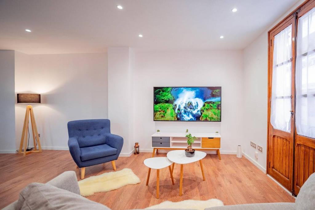 ein Wohnzimmer mit einem blauen Stuhl und einem Tisch in der Unterkunft El Pilar Luxury Suites By VALENCIAFLATS EU in Valencia