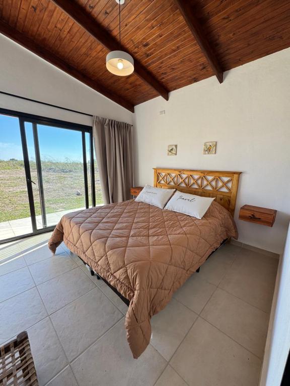 a bedroom with a bed and a large window at Cabaña YMBYATY in Colonia Carlos Pellegrini