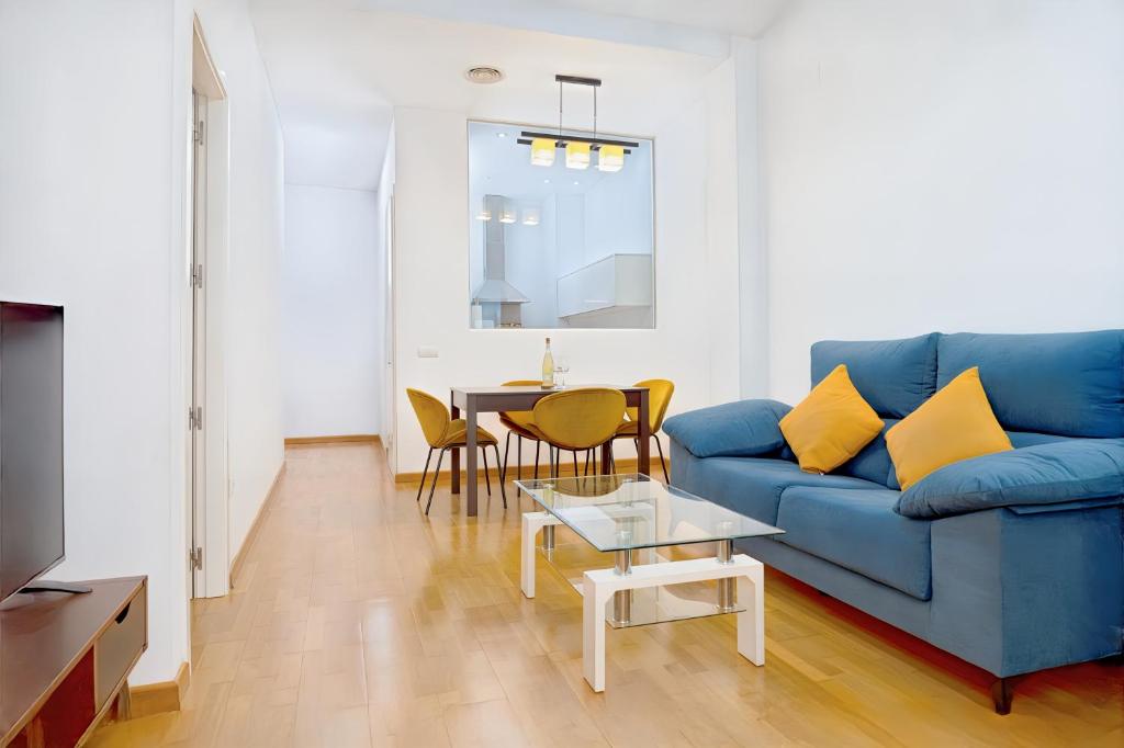 un soggiorno con un divano blu e un tavolo di Grand Central Market Suites By VALENCIAFLATS EU a Valencia