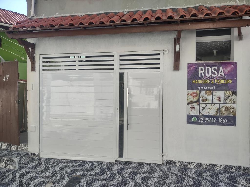 een witte garagedeur op een gebouw met een bord bij Espaço em Pero hospedagem in Cabo Frio