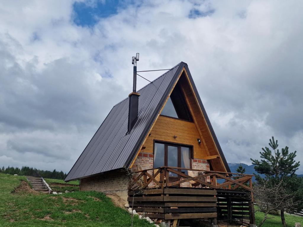a cabin with a metal roof on top of a hill at Vikendica Tromedja Pale in Pale