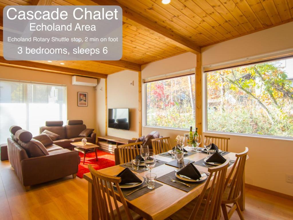 a dining room with a table and a couch at Morino Chalets in Hakuba
