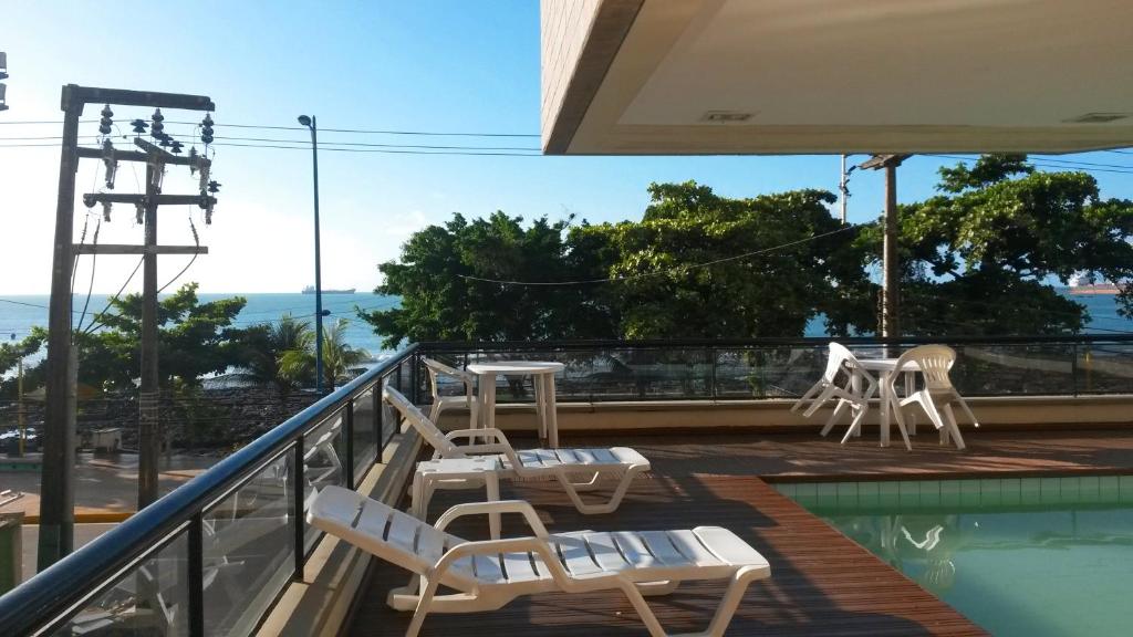 balcón con sillas y piscina en Villa Costeira Beira Mar, en Fortaleza