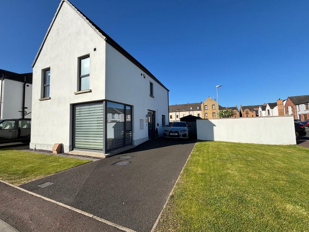 una casa blanca con entrada en un patio en Detached Modern Home Portstewart, en Portstewart