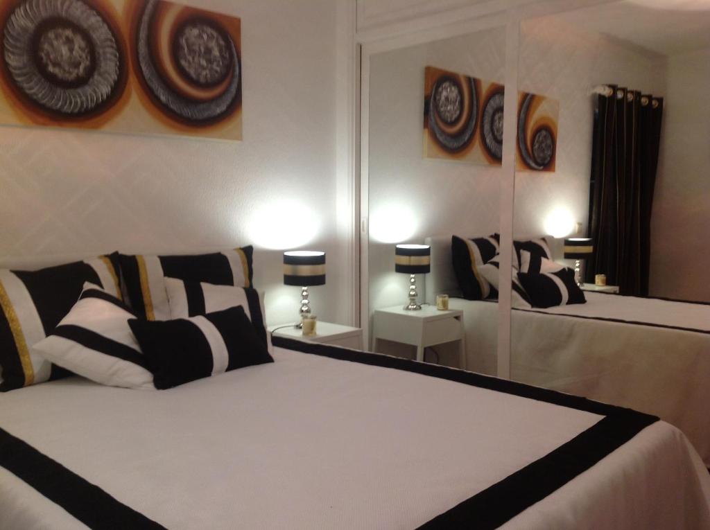 a bedroom with two beds and two mirrors at Casa do Mar in Sesimbra