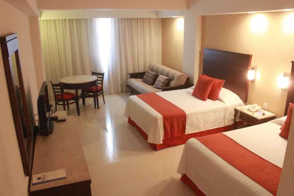 una habitación de hotel con 2 camas y una silla en Hotel Bello Veracruz, en Veracruz