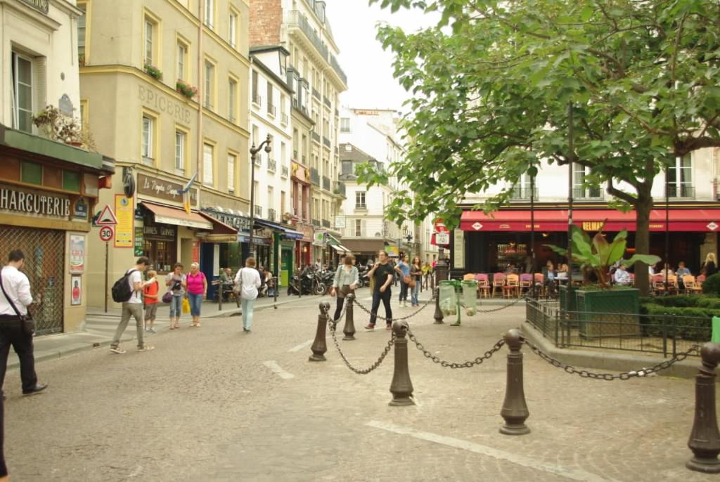 eine Stadtstraße mit Leuten, die auf der Straße laufen in der Unterkunft Studio Rue Lacépède in Paris