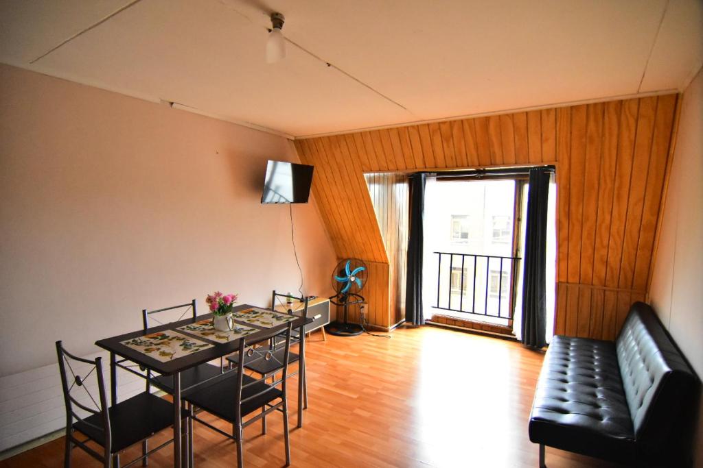 a dining room with a table and chairs and a couch at Dpto central y acogedor in Valdivia