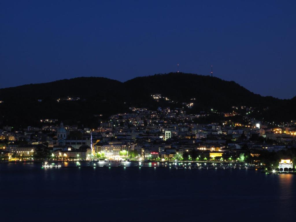a view of a city at night from the water at Como Luxury Rooms in Como
