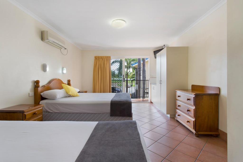 a bedroom with a bed and a dresser and a window at Glenmore Tavern in Rockhampton