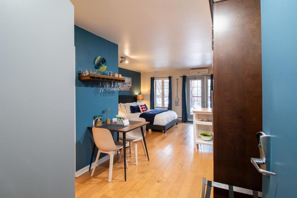 a living room with a table and a bedroom at Condo Hôtel Magog Orford in Orford