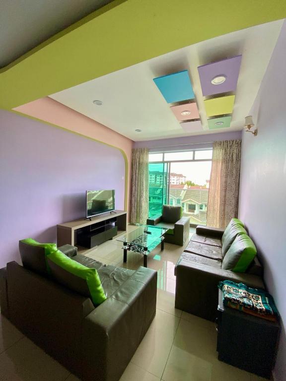 a living room with a couch and a television at SK Holiday Apartment in Tanah Rata