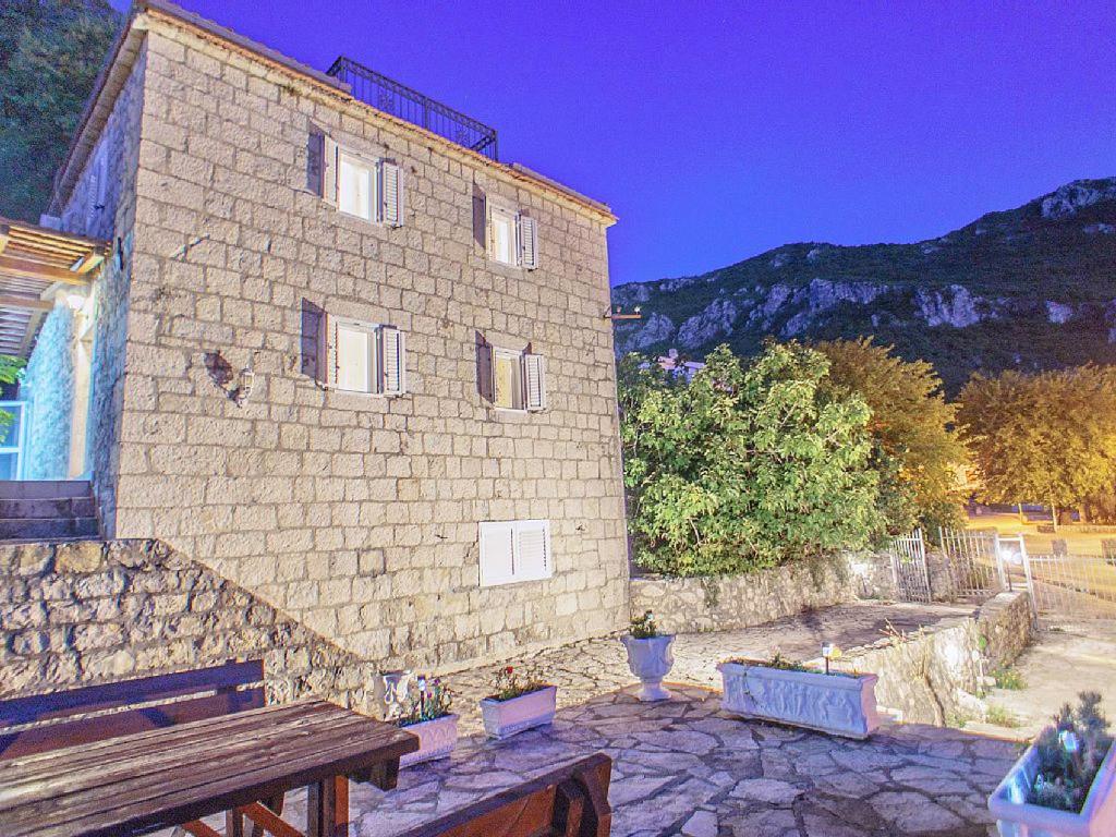 a large brick building with a bench in front of it at Holiday Home Danilo in Sveti Stefan