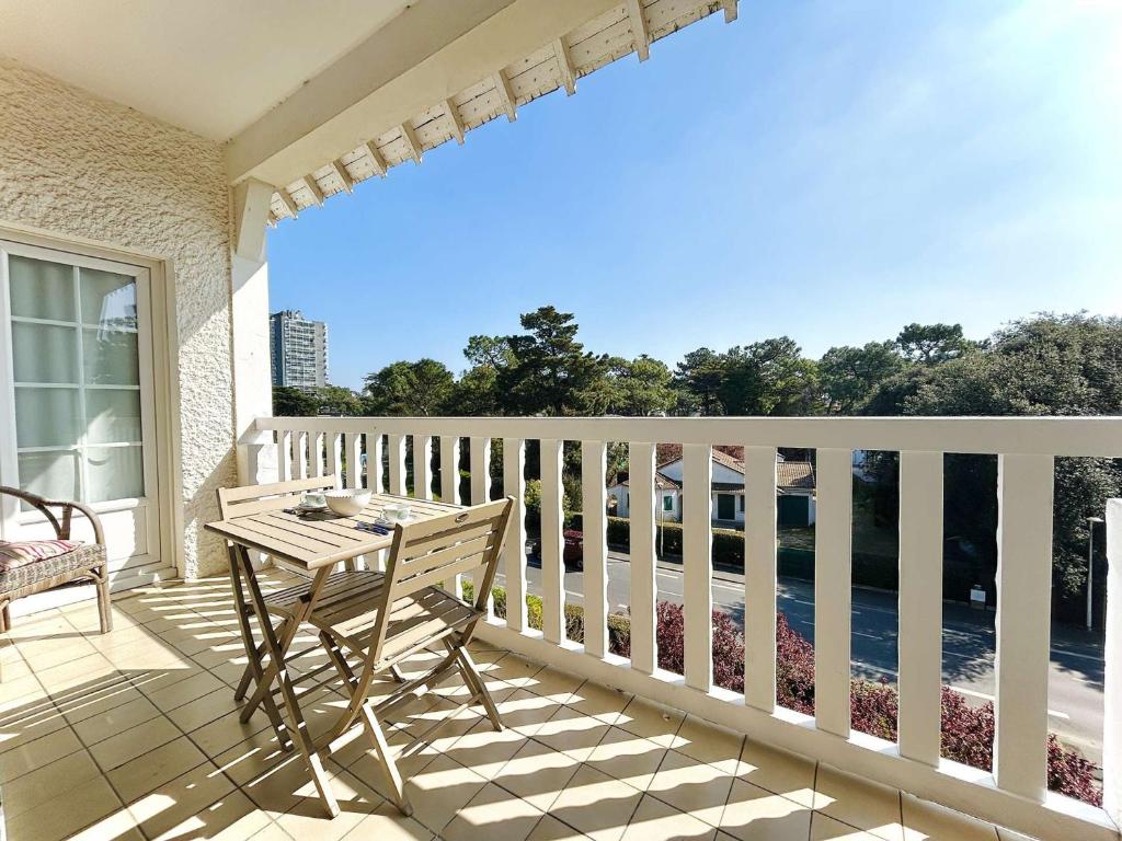 un porche avec une table et une chaise en bois sur un balcon dans l'établissement Appartement T3 moderne à La Baule, 6 pax - FR-1-245-215, à La Baule