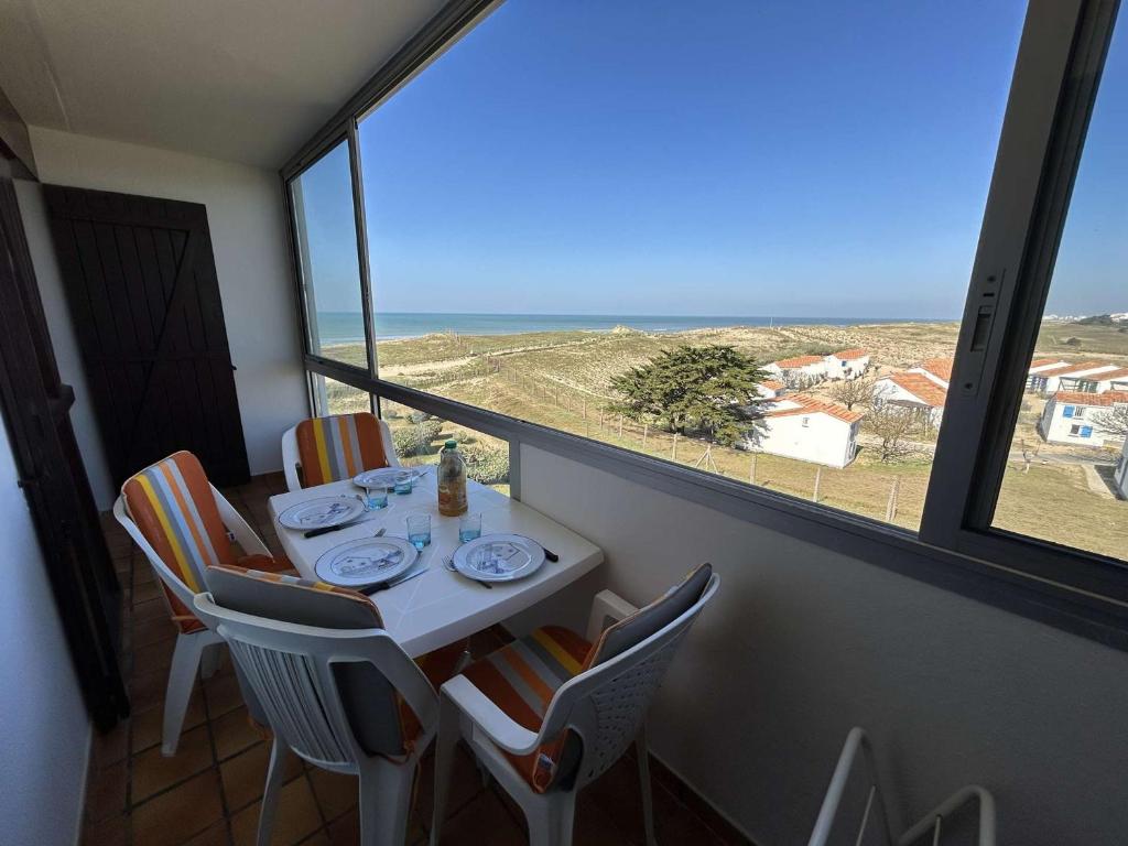 une table et des chaises dans une pièce avec vue sur l'océan dans l'établissement Appartement moderne 3 pièces, vue mer, parking privé, 5 couchages - FR-1-224C-348, à Saint-Hilaire-de-Riez