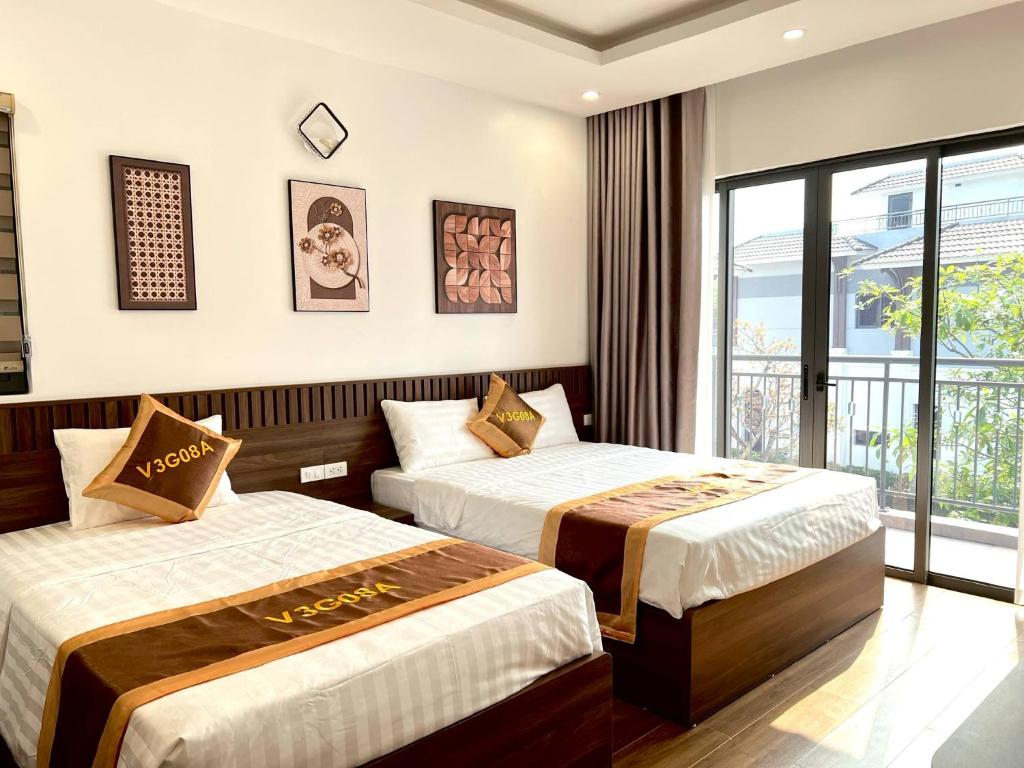 a hotel room with two beds and a window at Cozy Villa V3G08A in Sonasea - Vân Đồn - Gần biển- Đầy đủ tiện nghi in Thâm Câu