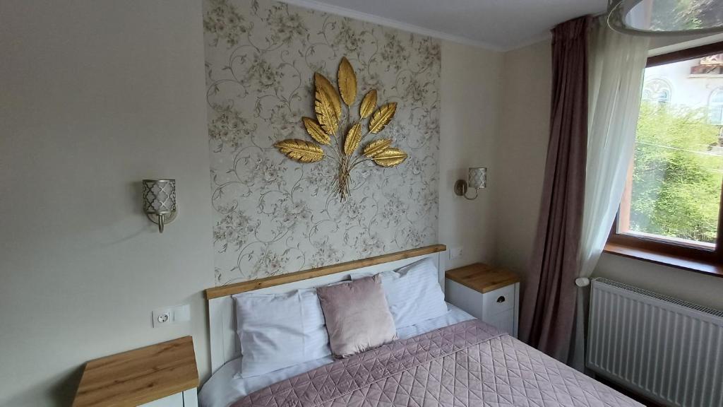 a bedroom with a bed with a leaf on the wall at Nobila in Sinaia