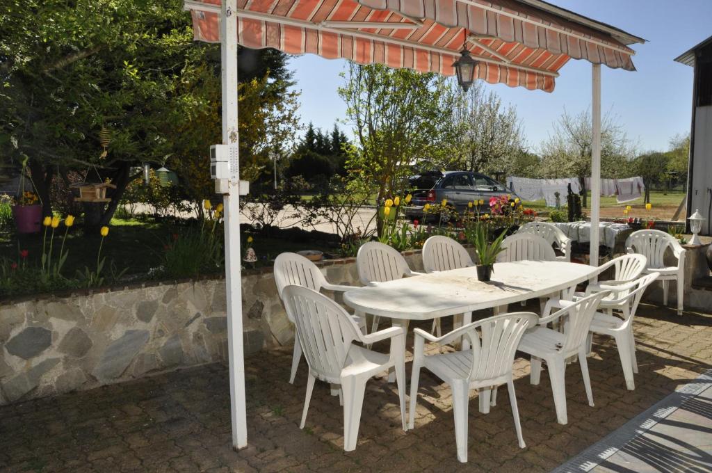a white table and chairs under an umbrella at Les rouches in Cormeray