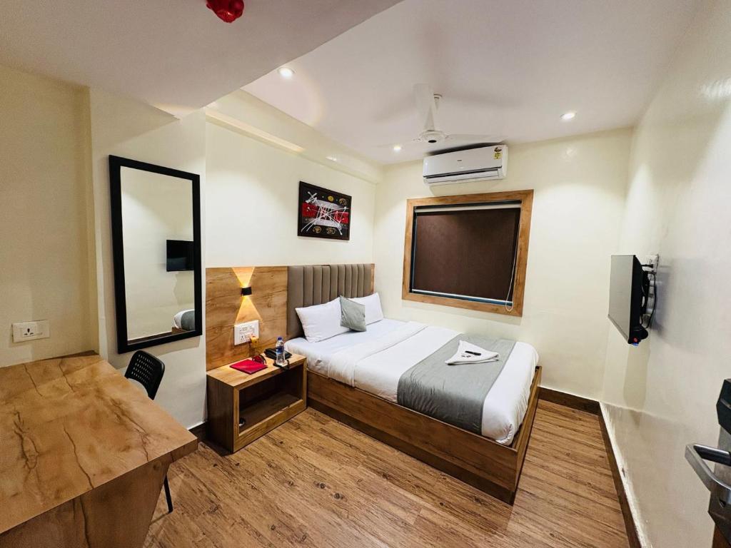 ムンバイにあるHotel Airport By TMAのベッドと薄型テレビがあるホテルの部屋