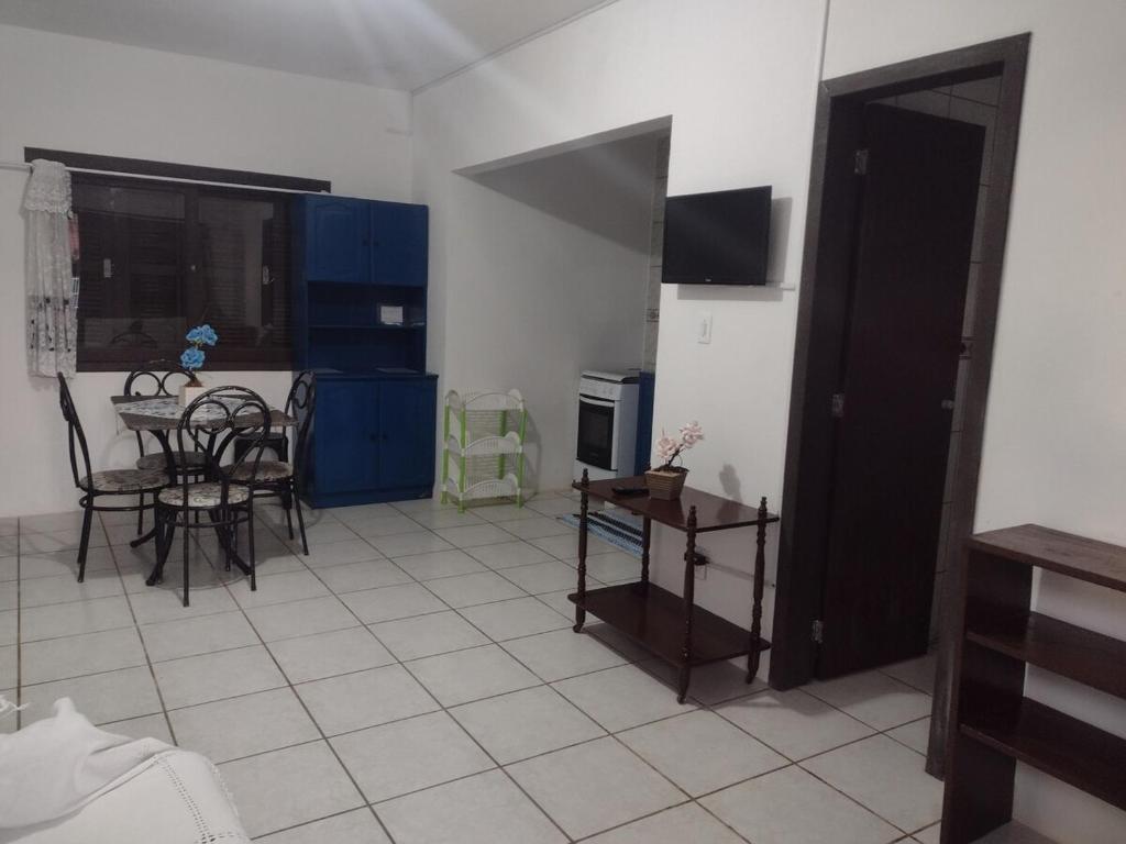 a kitchen with blue cabinets and a table and chairs at Cidreira-Salinas Casinha in Cidreira
