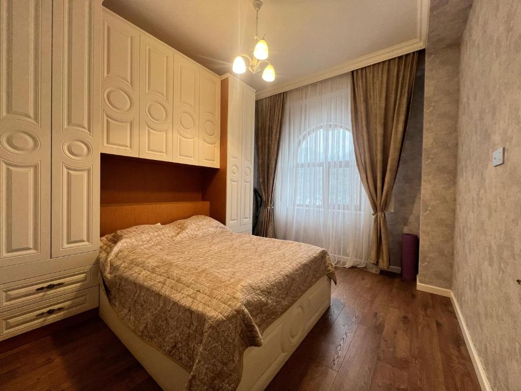 a bedroom with a bed and a window at Sumqayit Kristal3 in Sumqayıt