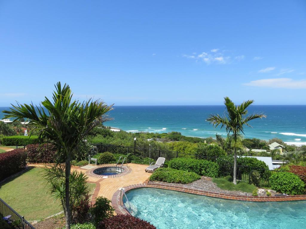 a view of a swimming pool and the ocean at Sunseeker Holiday Apartments in Sunshine Beach