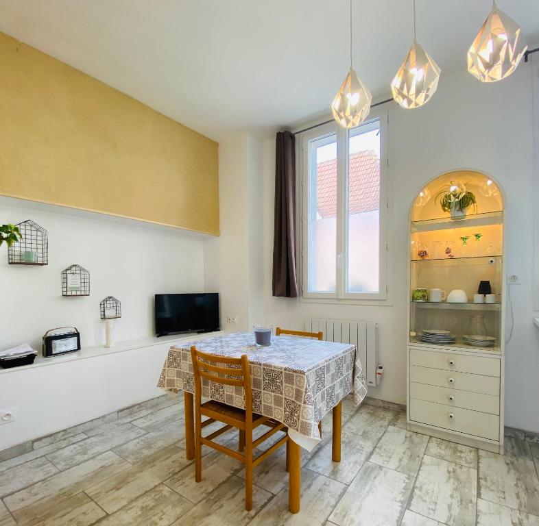 a dining room with a table and chairs and a window at La Chtite Maison Béarnaise in Arthez-de-Béarn