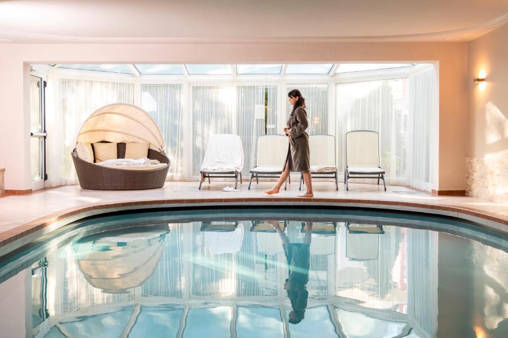 una mujer caminando junto a una piscina en Alpenhof Lodge Alpin Superior, en Saltusio