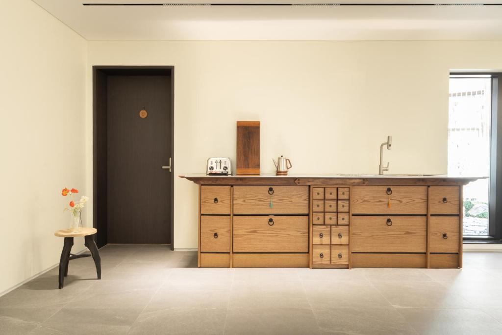 eine Küche mit einem Waschbecken und einem Holzschrank in der Unterkunft Boro Hanok Hostel in Myeongdong in Seoul