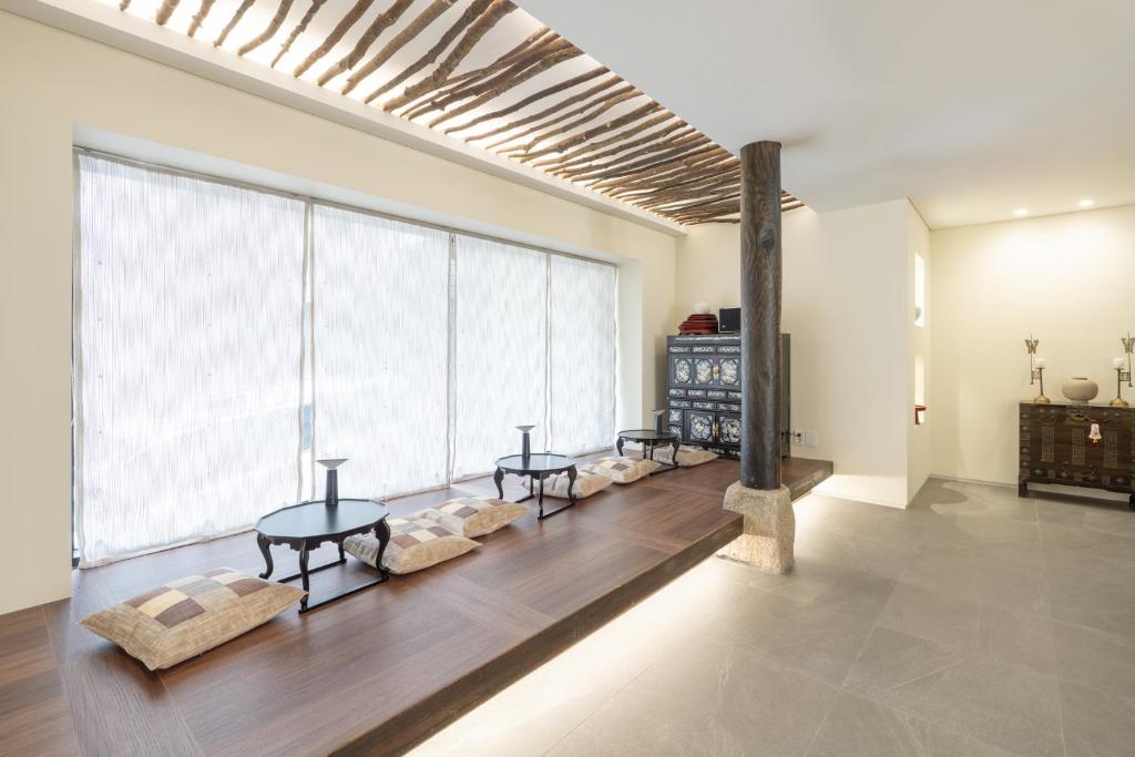 ein Wohnzimmer mit 2 Tischen und einem großen Fenster in der Unterkunft Boro Hanok Hostel in Myeongdong in Seoul