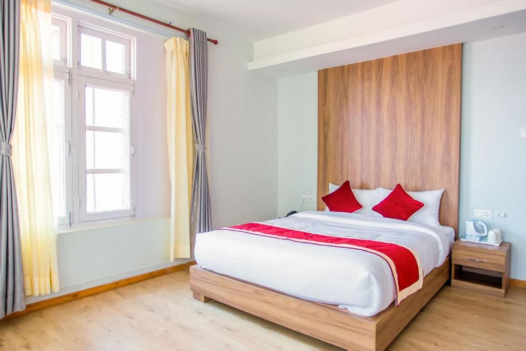 a bedroom with a large bed with red pillows at Paradise Hills in Bungmati
