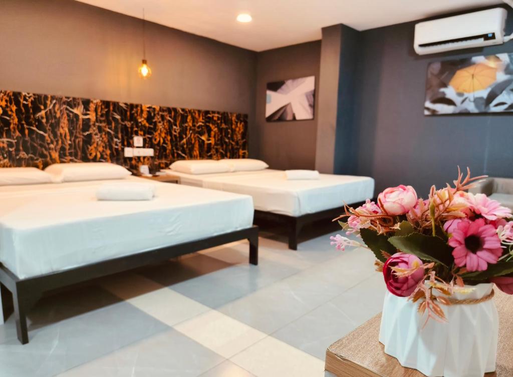Habitación con 2 camas y flores. en Maine City Residences Tramo, en Manila