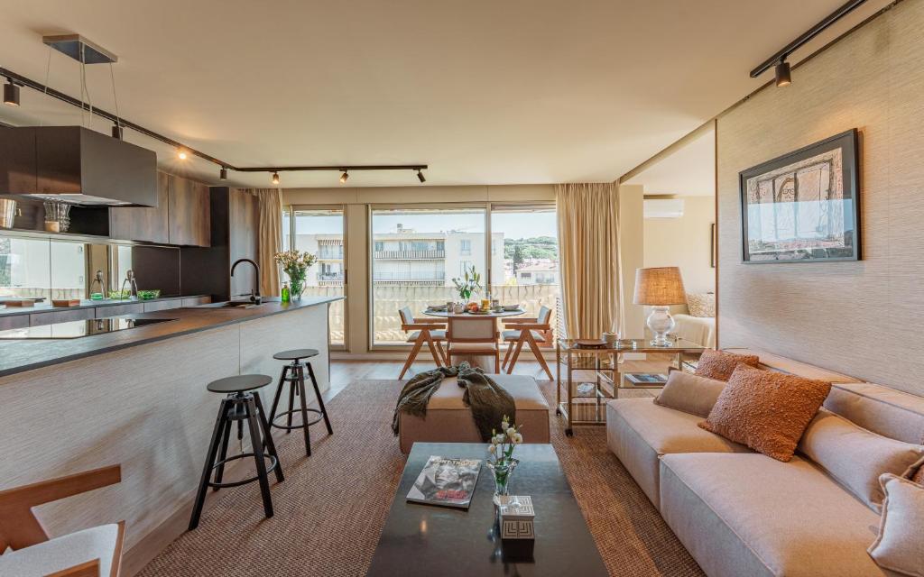 un salon avec un canapé et une cuisine dans l'établissement Appartement Chic 3 Chambres Saint-Tropez, à Saint-Tropez