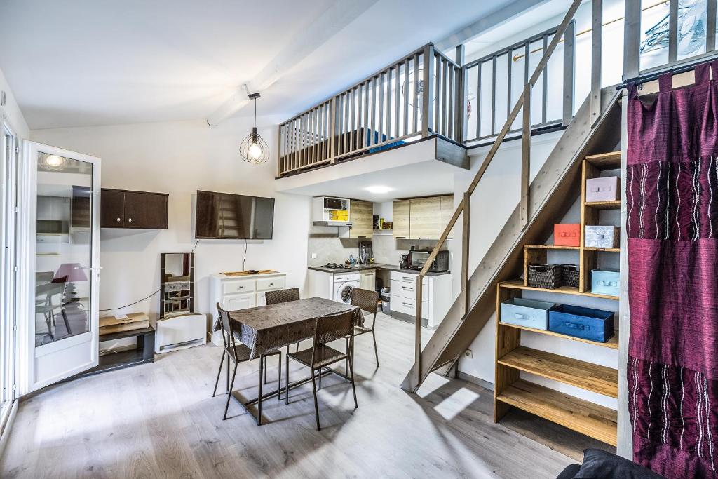 une cuisine avec une table et un escalier dans l'établissement Le Repaire du Sud - 8min de la Plage, à Saint-Cyprien