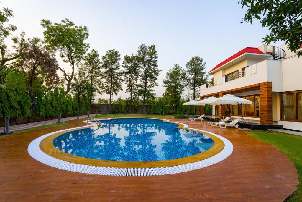Bazén v ubytování ELIVAAS Sanisa Farm 3-BHK Farmhouse with Pvt Pool, Game Zone & Lush Garden nebo v jeho okolí