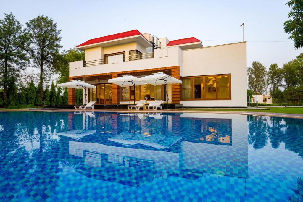 Bazén v ubytování ELIVAAS Sanisa Farm 3-BHK Farmhouse with Pvt Pool, Game Zone & Lush Garden nebo v jeho okolí