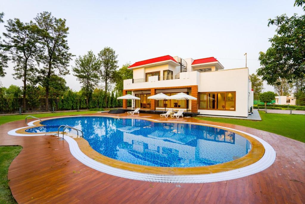 Bazén v ubytování ELIVAAS Sanisa Farm 3-BHK Farmhouse with Pvt Pool, Game Zone & Lush Garden nebo v jeho okolí