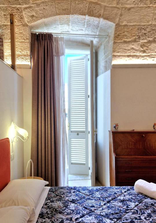 a bedroom with a bed and a door to a window at MandorleOlio in Polignano a Mare