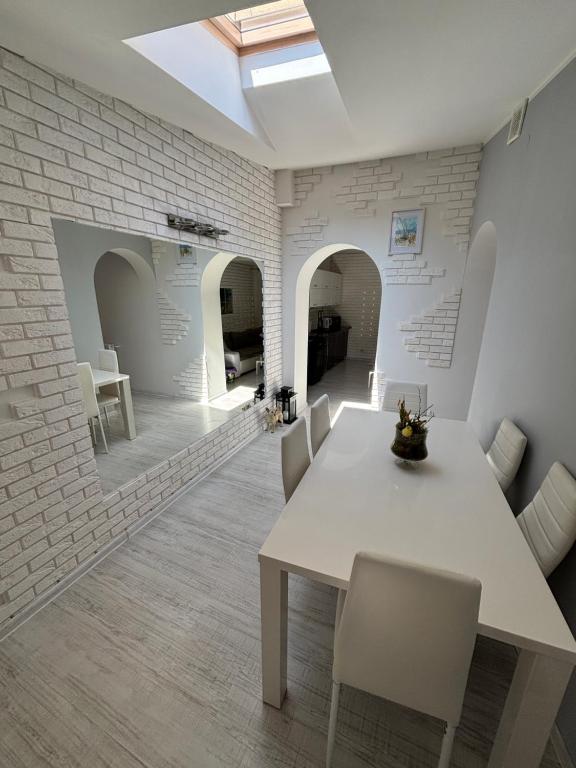 a dining room with a white table and chairs at Apartament Konopnickiej in Dziwnów