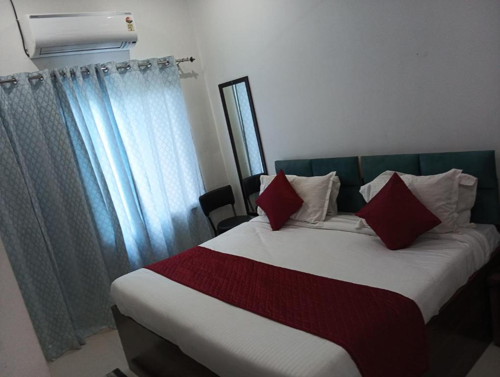 a bed with red and white pillows in a room at Shree shyam pay at hotel in Khātu