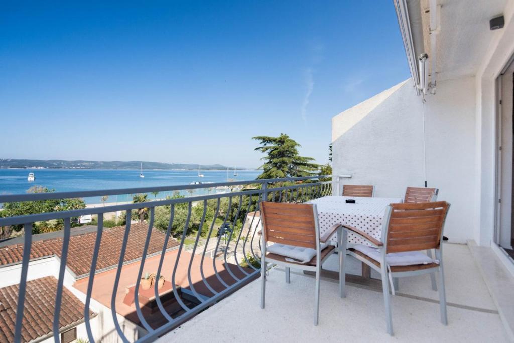 balkon z 2 krzesłami i stołem oraz ocean w obiekcie Apartment Rajna w Biogradzie na Moru