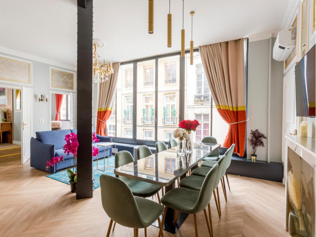 une salle à manger avec une table en verre et des chaises vertes dans l'établissement Merveil - Luxury Suite - Louvre - Reaumur I, à Paris