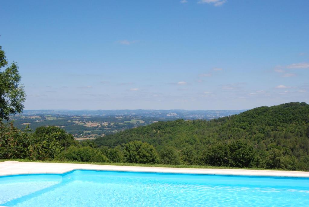 une piscine avec vue sur une montagne dans l'établissement Les Charmes de Grèzes- location de samedi à samedi, à Grèzes