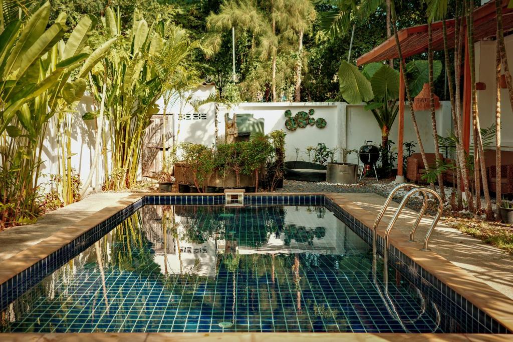 una piscina en un patio con plantas en Beachfront pool villa, en Kamala Beach