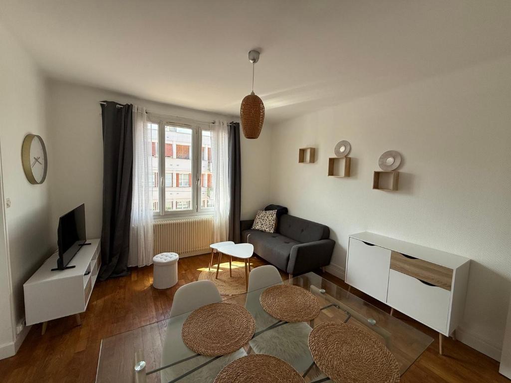 un salon avec un canapé et une télévision dans l'établissement Comfort in the Heart of Dijon, à Dijon