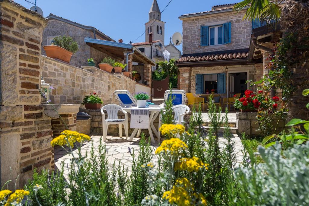een patio met een tafel en stoelen in een tuin bij St. Bernhard House in Funtana