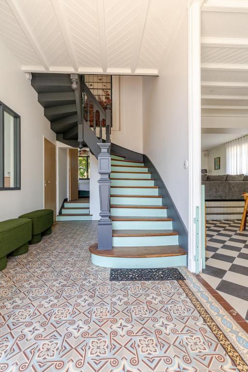 un escalier dans un immeuble avec un sol carrelé dans l'établissement Maison Bois Roux Charme & confort à 200m de la mer, à Préfailles