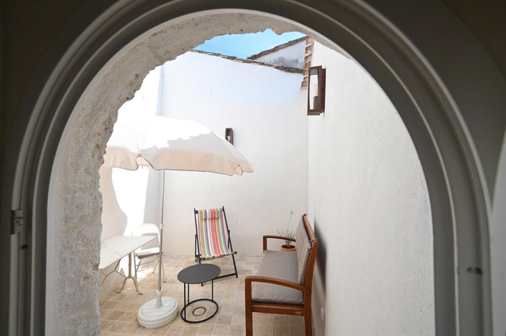 une arche dans une pièce avec une chaise et un parapluie dans l'établissement 535 Le Duplex - Renovated and bright house, à Saint-Martin-de-Ré